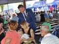 Burmistrz częstuje mieszkańców chlebem z tegorocznych zbiorów.